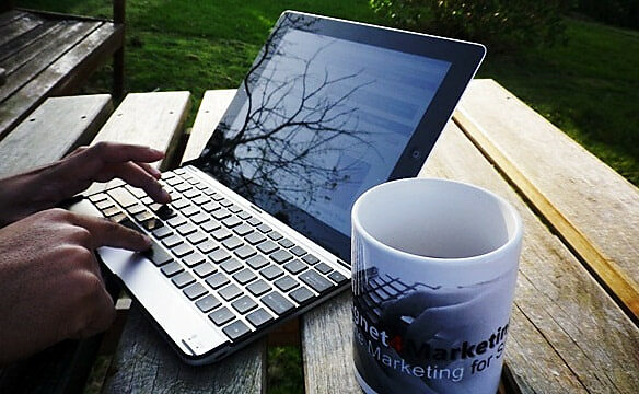 Laptop computer and coffee on outdoor table
